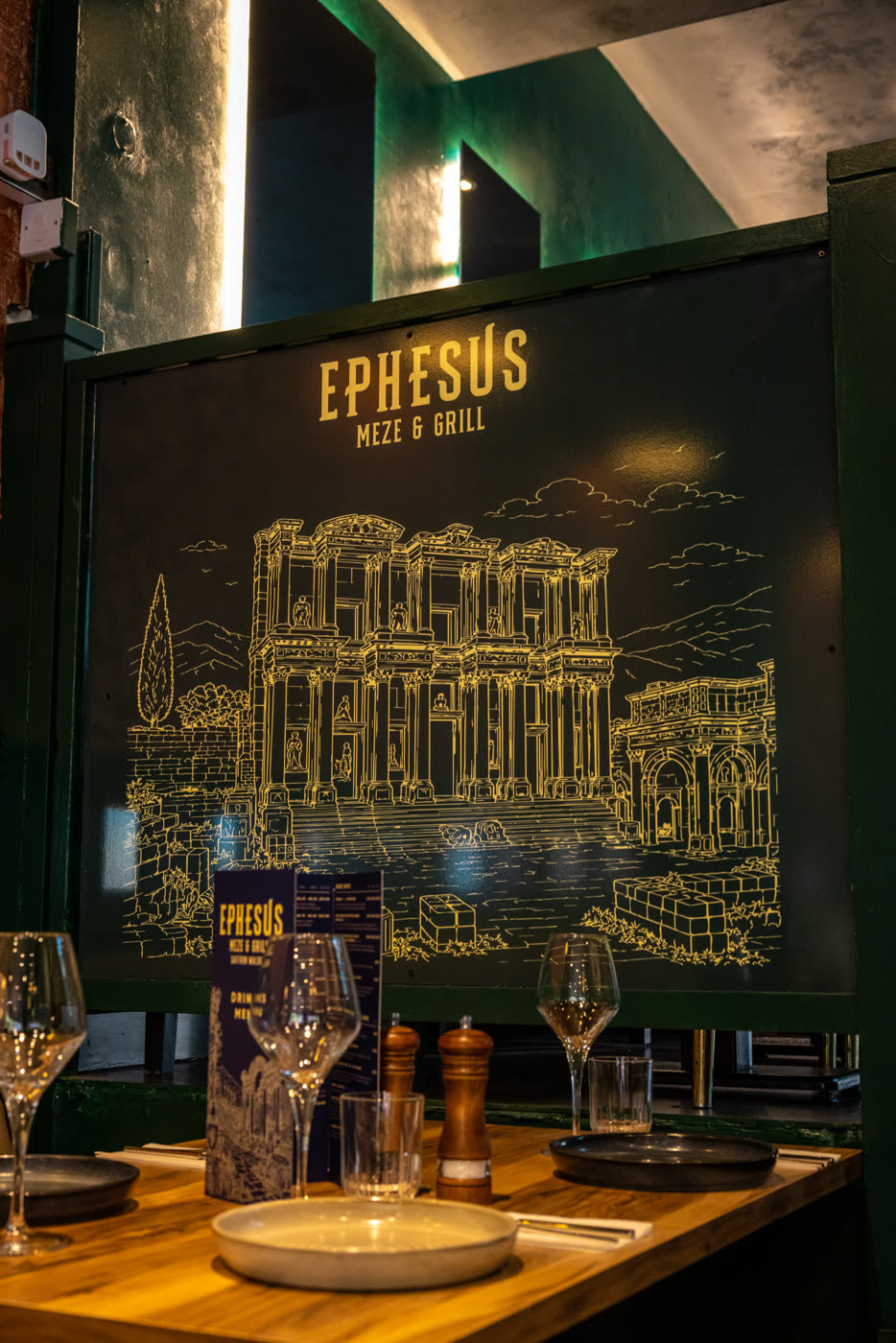 A table set beneath the Ephesus mural